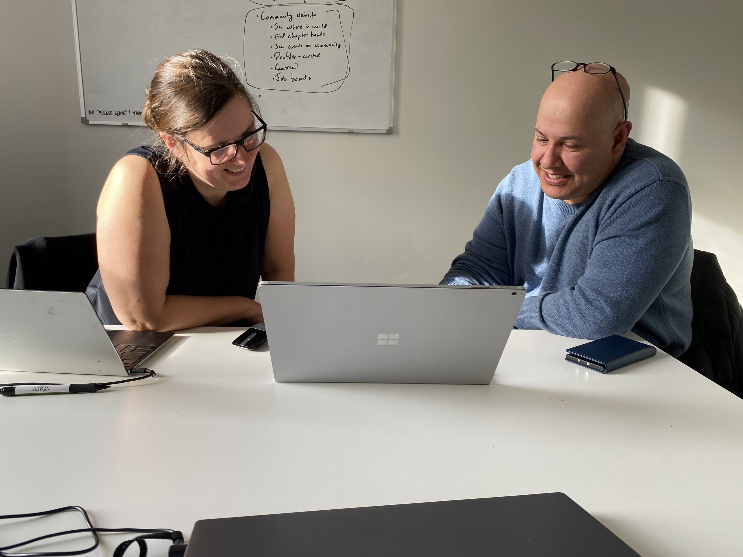 Dr Casebourne collaborating with Dr Abu Sitta, seated with a table and using a laptop